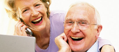 Couple laughing on cell phone and on laptop (h)